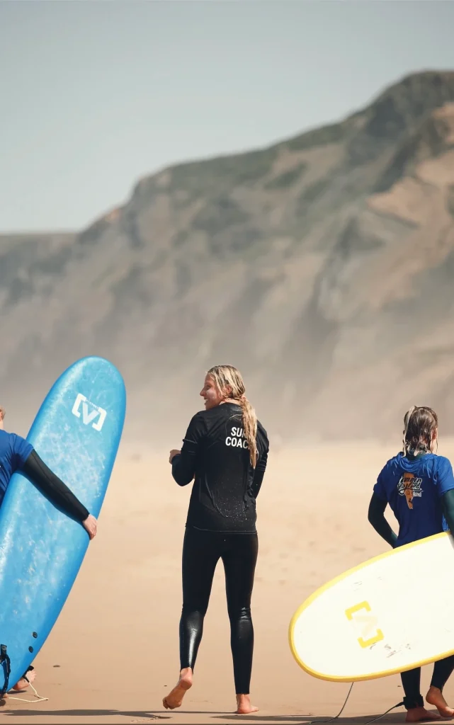 👉 "Beginner surfers learning to ride waves during a surf lesson at Sagres Sun Stay."